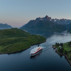 Hurtigruten Kreuzfahrtschiff in norwegischer Fjordlandschaft, ab Frankfurt mit Direktflug.