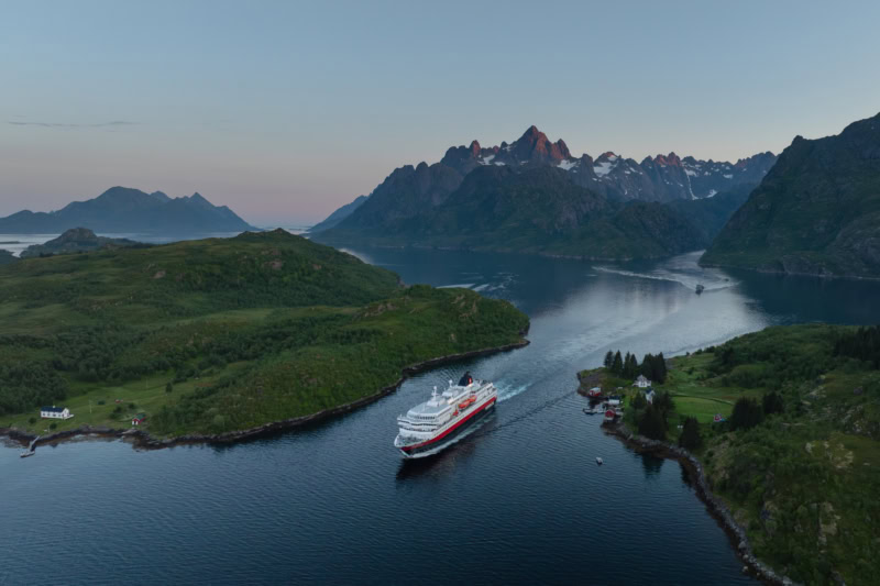 Hurtigruten Kreuzfahrtschiff in norwegischer Fjordlandschaft, ab Frankfurt mit Direktflug.